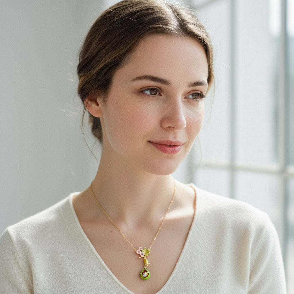Woman wearing a necklace with a floral pendant in a softly lit room