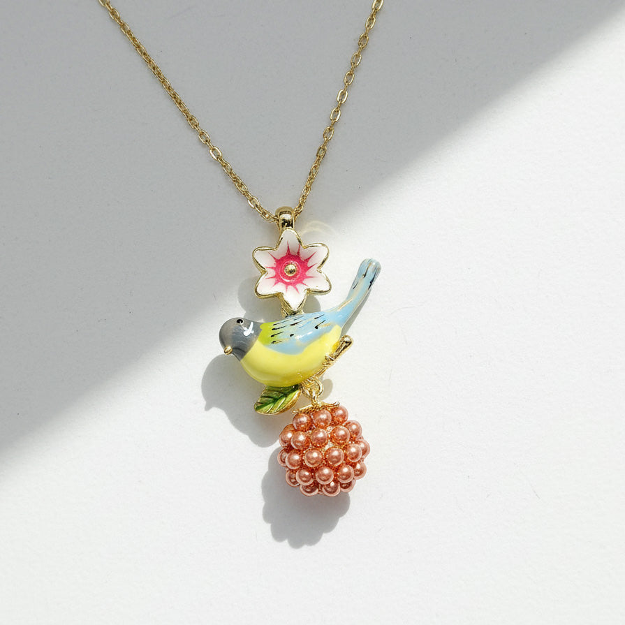 Necklace with a bird and flower pendant on a light gray background