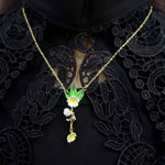 Close-up of a woman wearing a gold-plated panda pendant necklace with green leaf and yellow flower details, styled over black lace clothing.