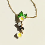 Necklace with panda and flower pendant on a beige background