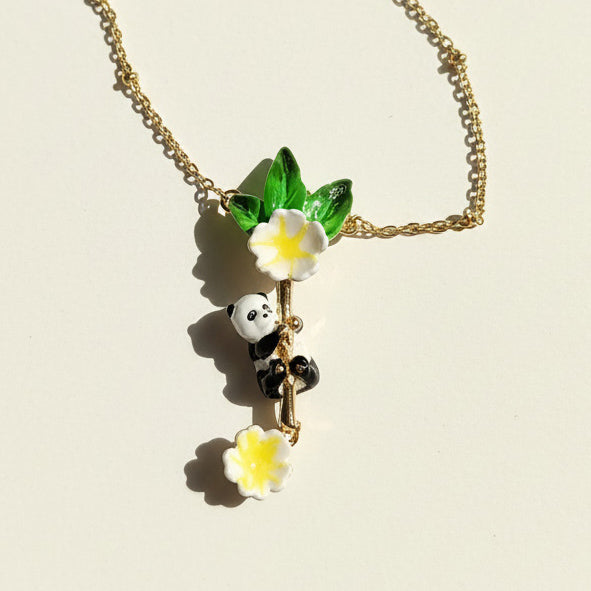 Necklace with panda and flower pendant on a beige background