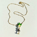 Gold necklace with panda and flower pendant on a light background