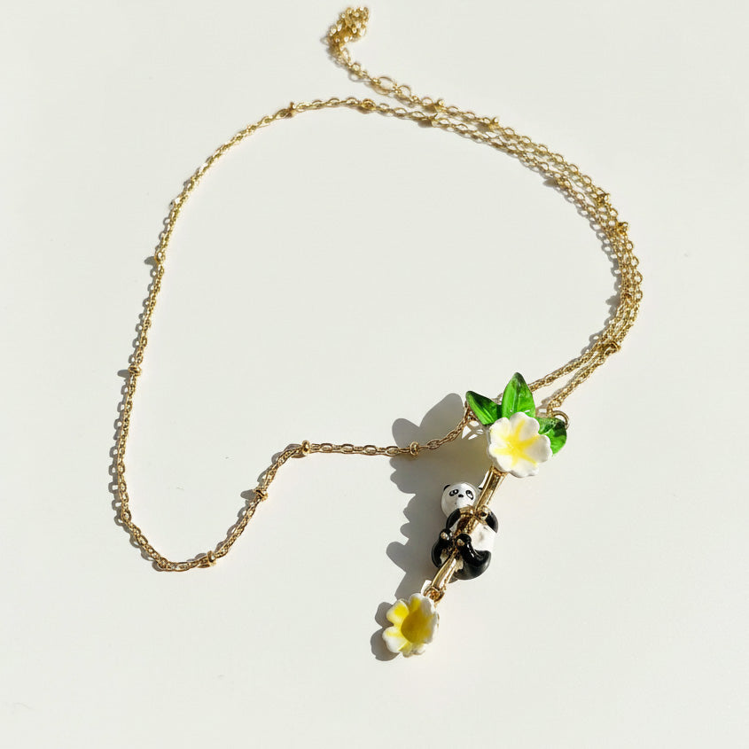 Gold necklace with floral pendants on a light background