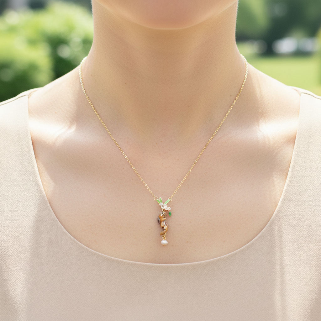 Necklace with a pendant on a mannequin against a blurred green outdoor background
