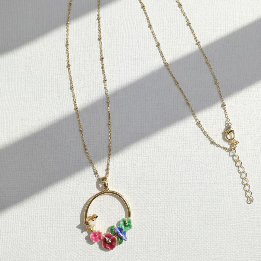 Gold necklace with floral pendant on a white background