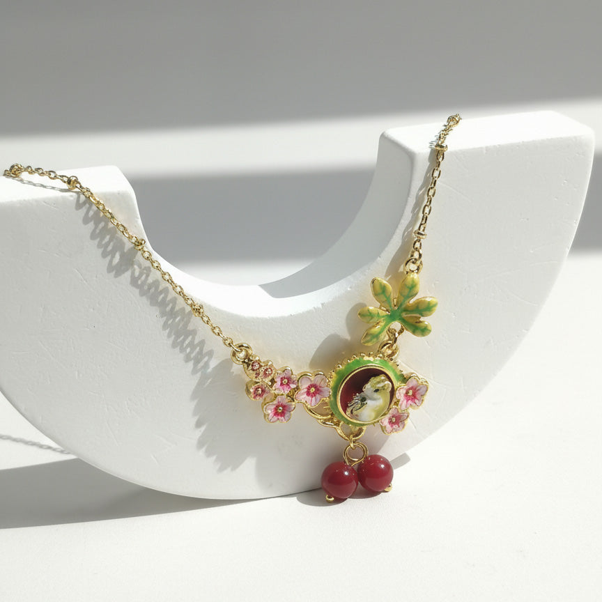 Necklace with floral and mouse pendant on a white dish