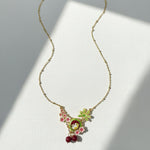 Necklace with floral and fruit pendant on a white background