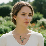 Woman wearing a necklace with a floral pendant in a garden setting