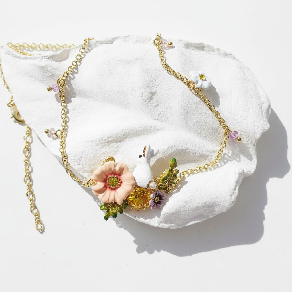 Necklace with floral and bunny pendant on a white leaf