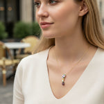 Woman wearing a necklace with a colorful pendant in an outdoor setting