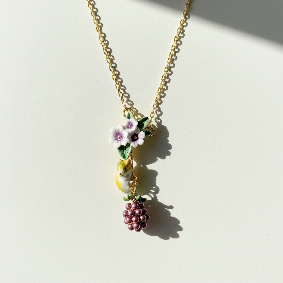 Necklace with floral and berry pendant on a light background