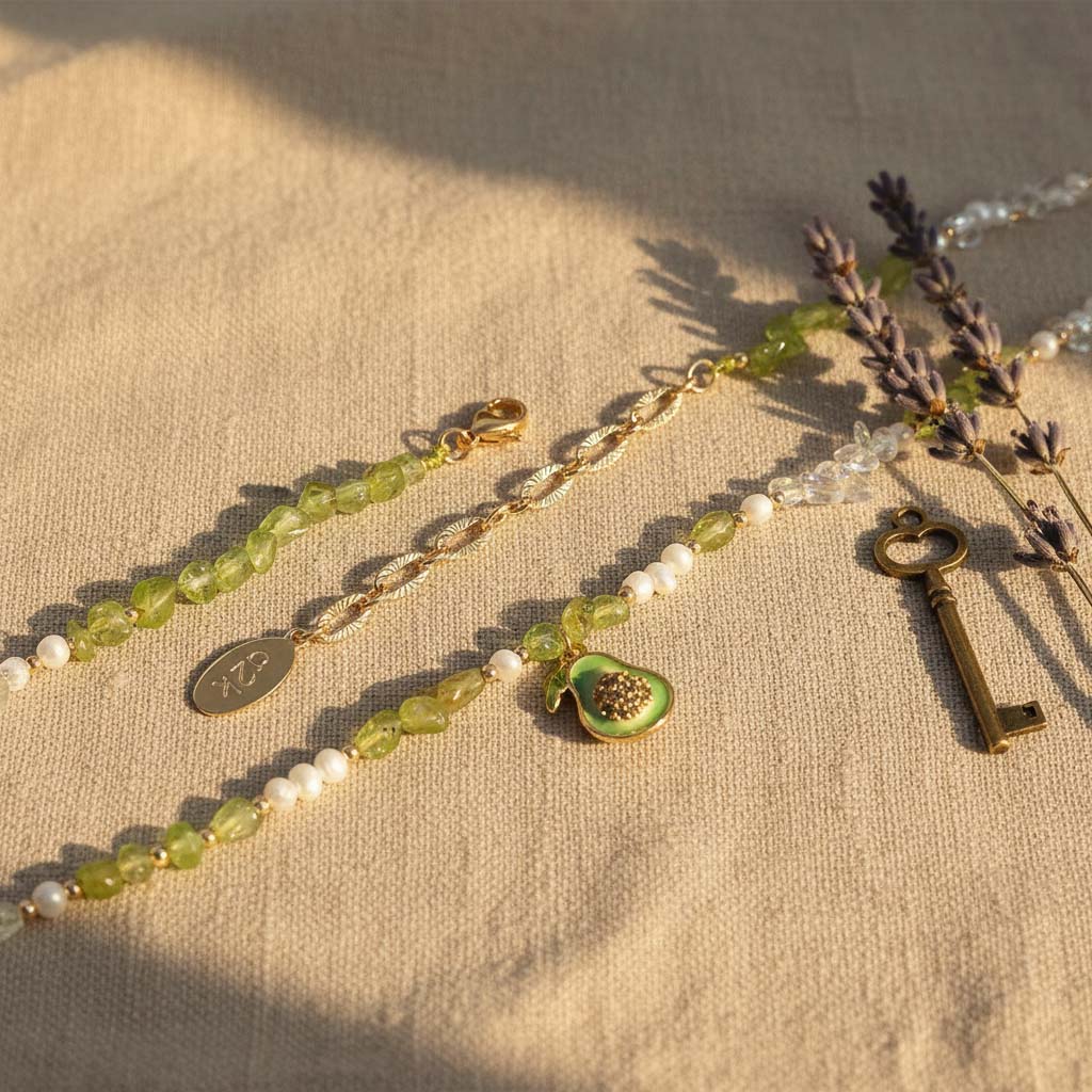 Necklace with green beads, white pearls, and a key charm on a beige fabric background