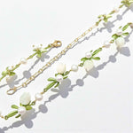 Necklace with floral and pearl design on a light background