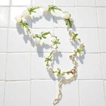 Necklace with floral design on a white tiled background