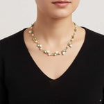 Pearl necklace worn by a person against a neutral background
