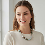 Woman wearing a necklace with a plain background