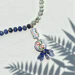Necklace with blue and green beads on a light background