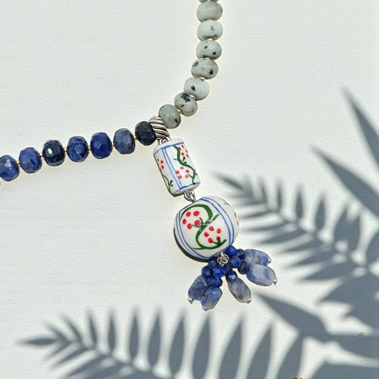 Necklace with blue and green beads on a light background