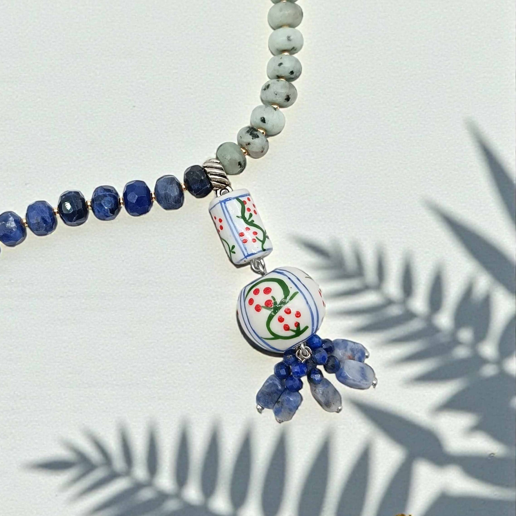 Necklace with blue and green beads on a light background