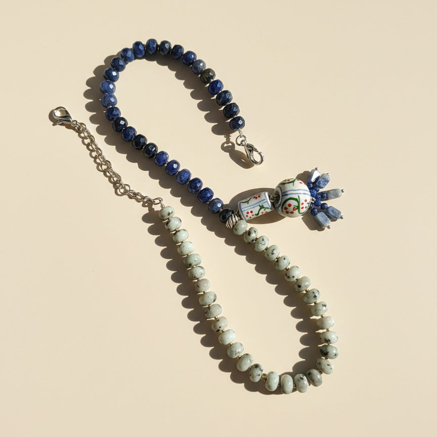 Necklace with blue and green beads on a beige background