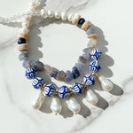 Hand-painted porcelain bead and pearl statement necklace with baroque pearl drops on marble background.