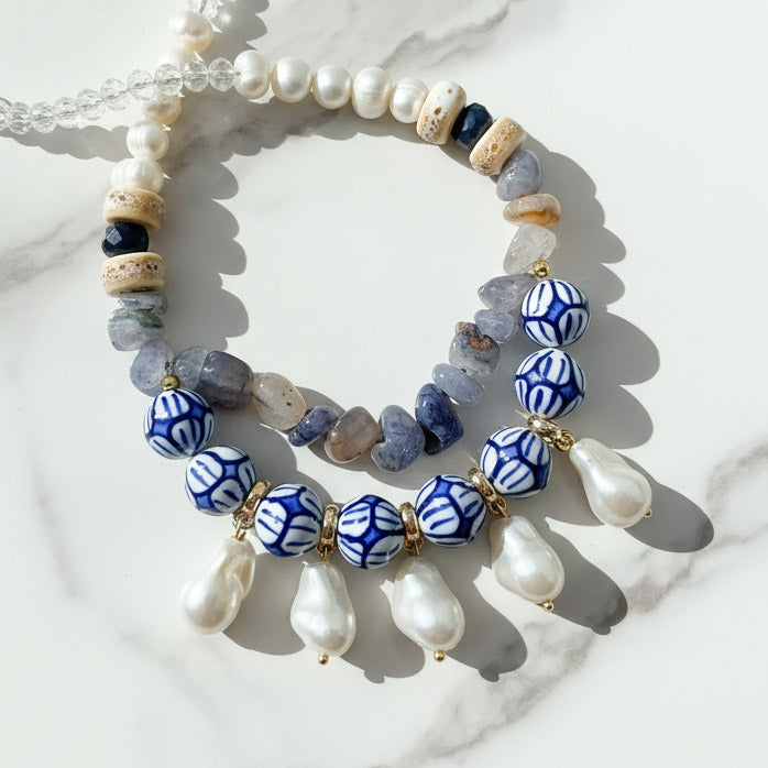 Hand-painted porcelain bead and pearl statement necklace with baroque pearl drops on marble background.