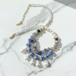 Artistic porcelain and pearl necklace with blue painted beads, freshwater pearls, and baroque drops.