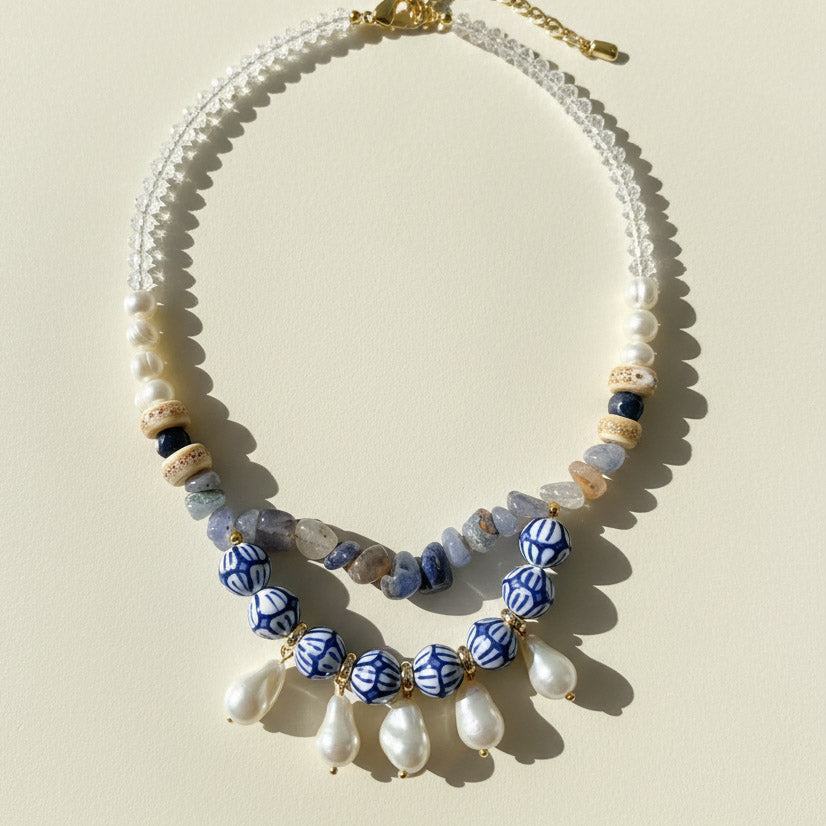 Necklace with blue and white patterned beads on a beige background