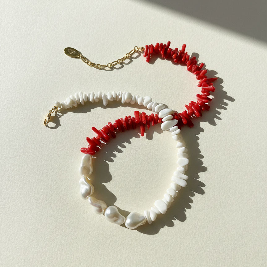 Necklace with red coral and white pearls on a light background