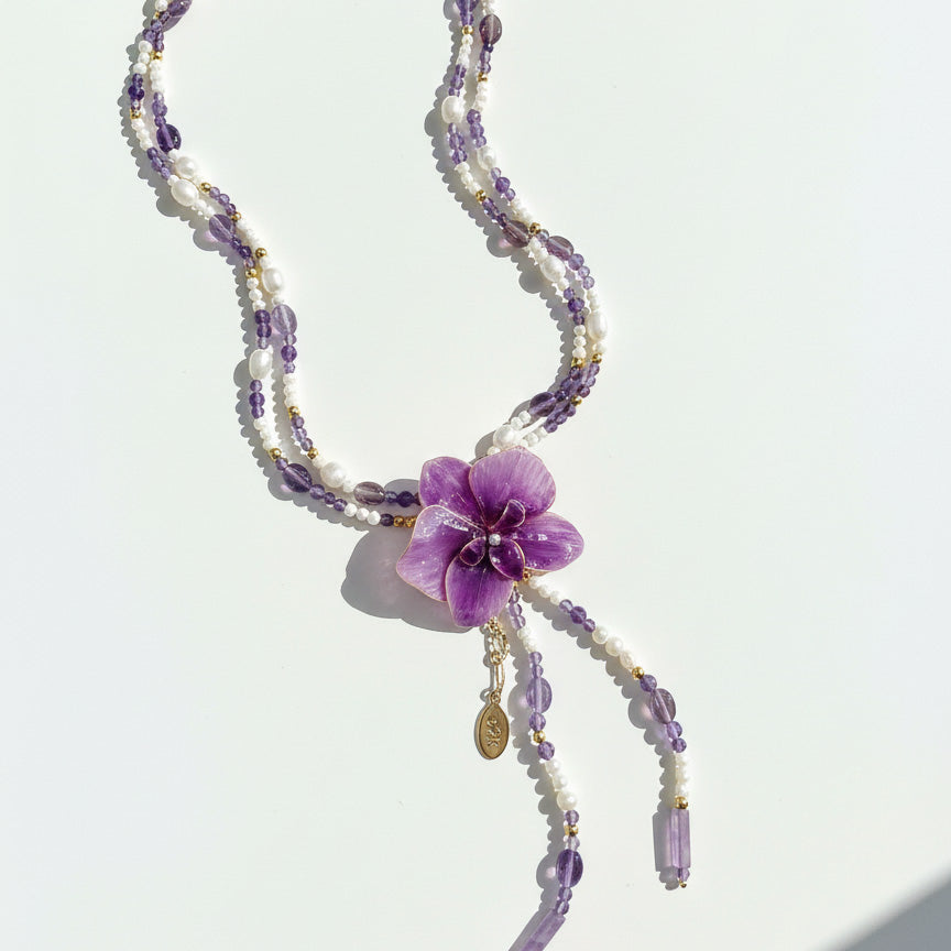 Necklace with a purple flower pendant on a white background