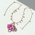Necklace with a pink flower pendant on a light background