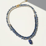 Multistrand necklace with blue beads and gold accents on a white background