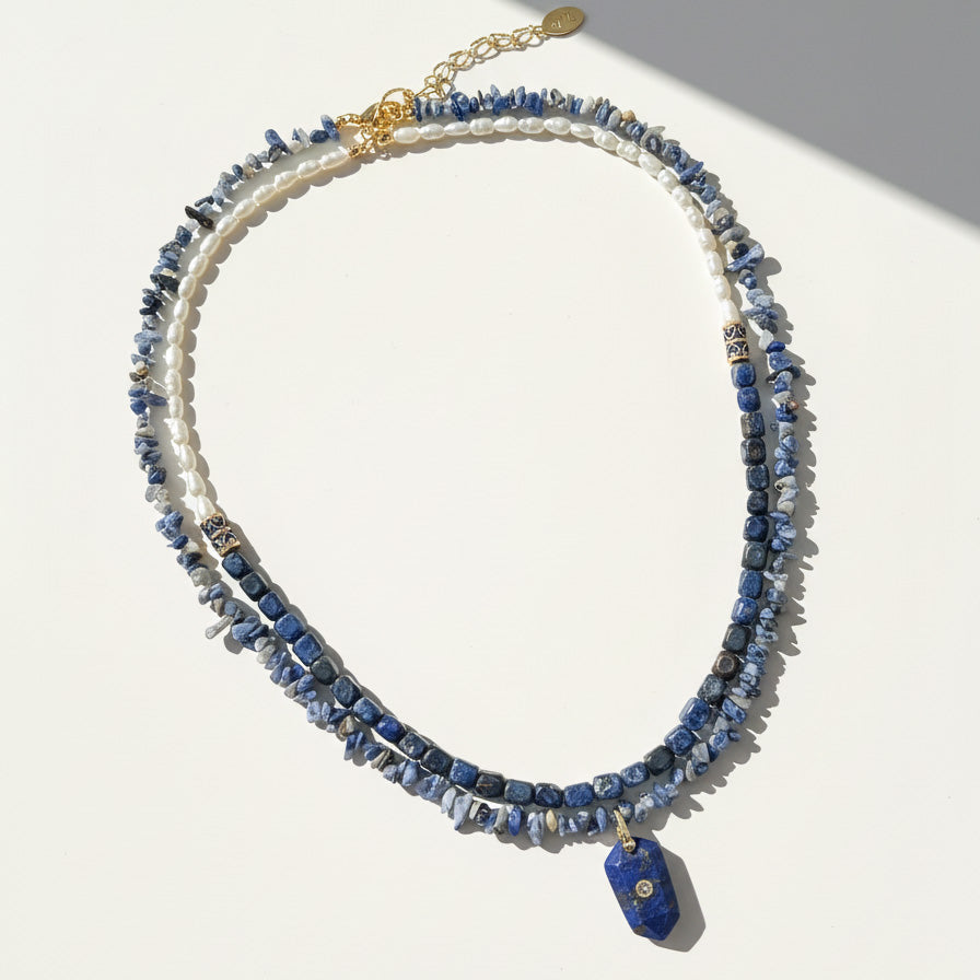Multistrand necklace with blue beads and gold accents on a white background