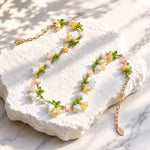 Spring Blossom Garden Necklace with Glass Flowers, Semi-Precious Stones and Enamel Leaves on a white stone surface