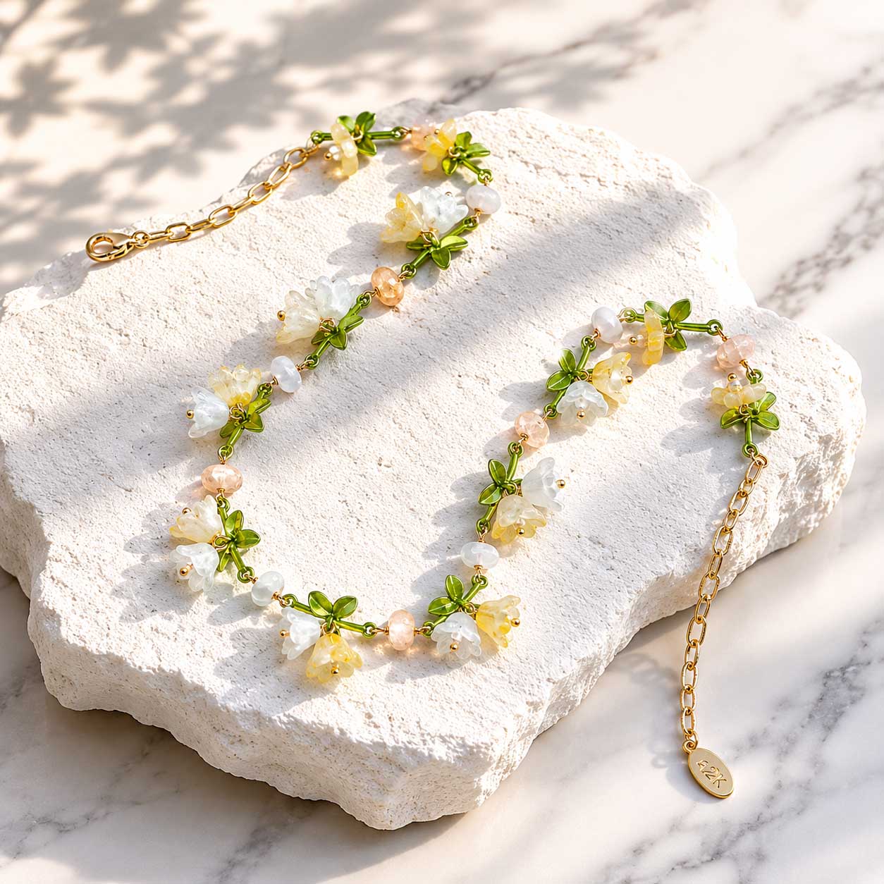 Spring Blossom Garden Necklace with Glass Flowers, Semi-Precious Stones and Enamel Leaves on a white stone surface