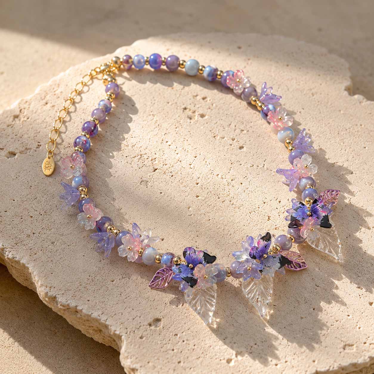 Close-Up of Butterfly Bloom Garden Necklace with Handcrafted Floral and Butterfly Details on a stone surface