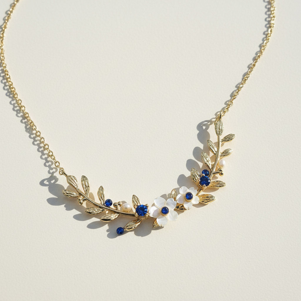Gold necklace with floral design on a light beige background