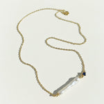 Gold necklace with a pendant on a light background