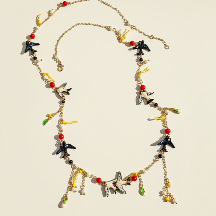 Swallow and pearl necklace with red beads and gold-plated accents.