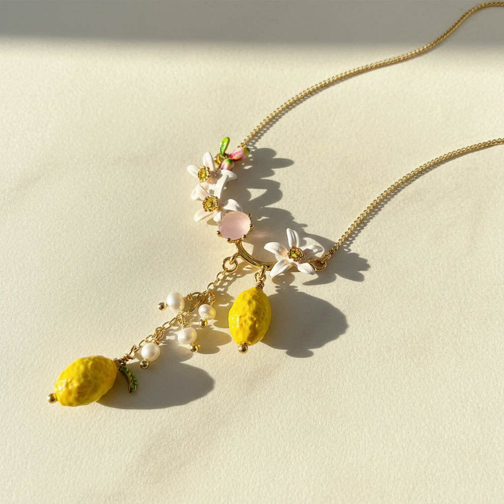 Necklace with floral and fruit-shaped pendants on a light background