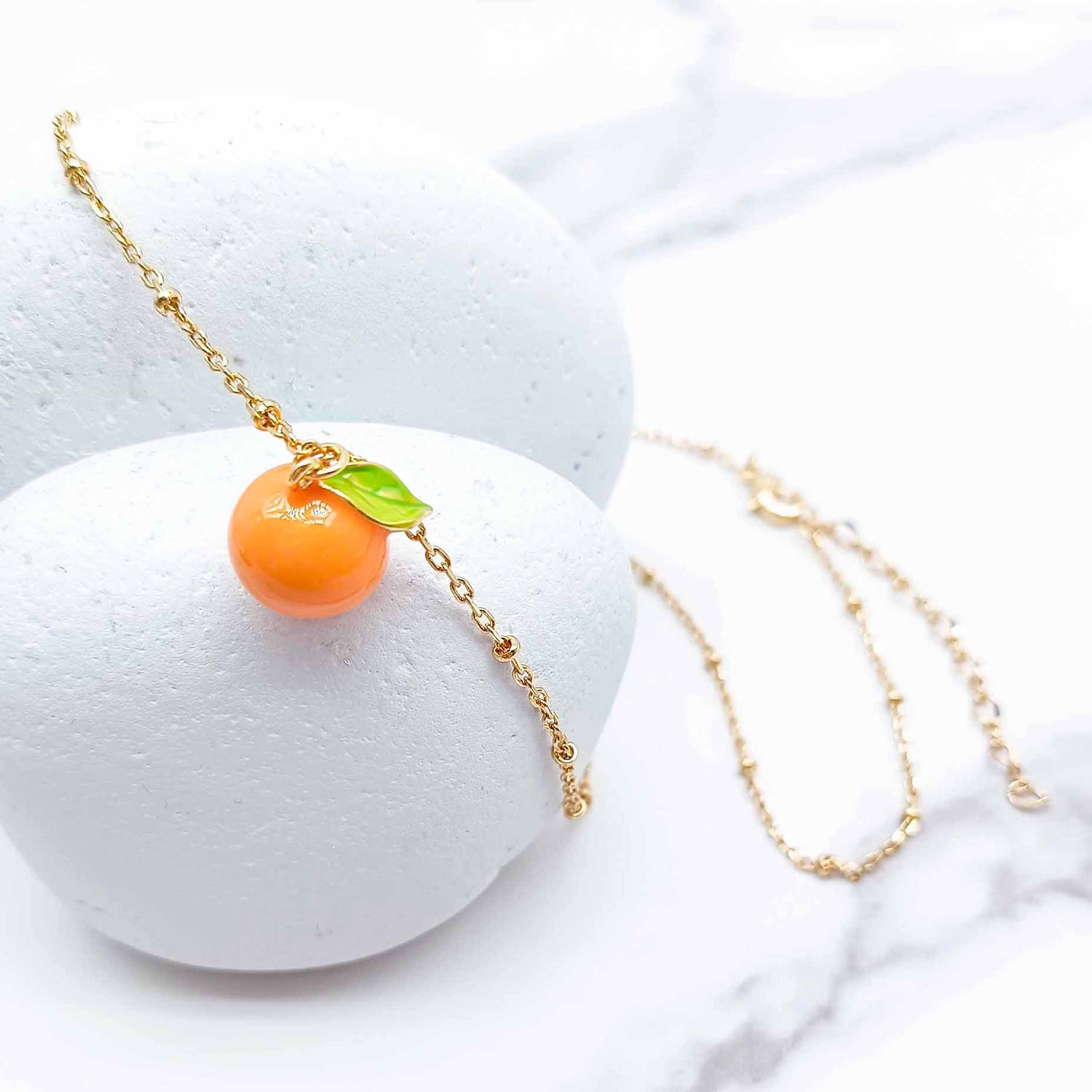 Necklace with an orange pendant on a white background