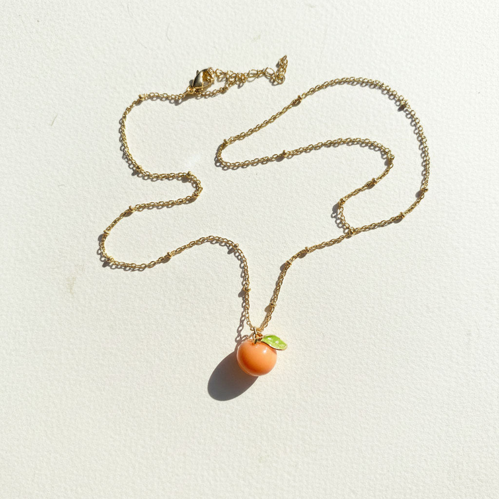 Necklace with a Mandarin-shaped pendant on a light background