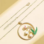 Gold necklace with a floral pendant on a beige background