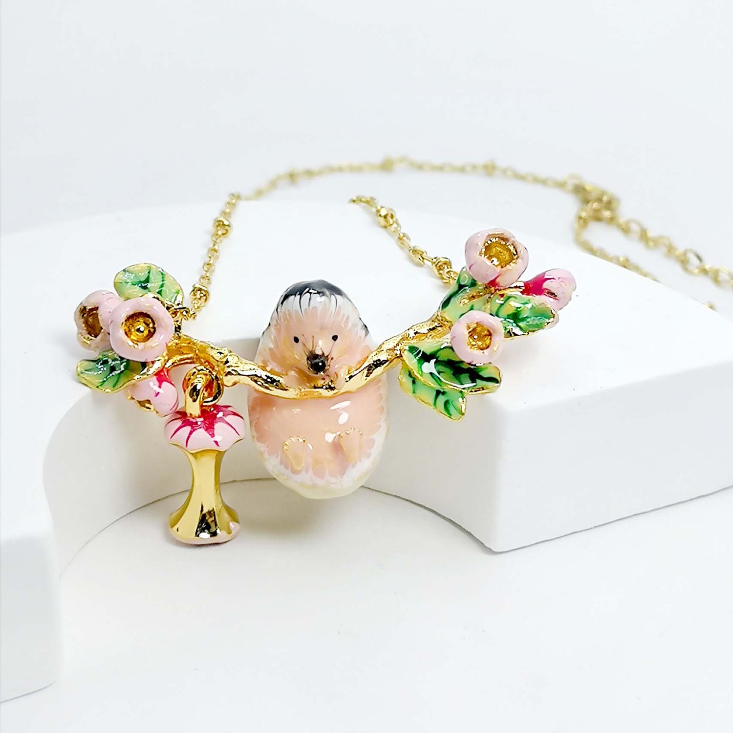 Necklace with a hedgehog pendant and floral elements on a white background