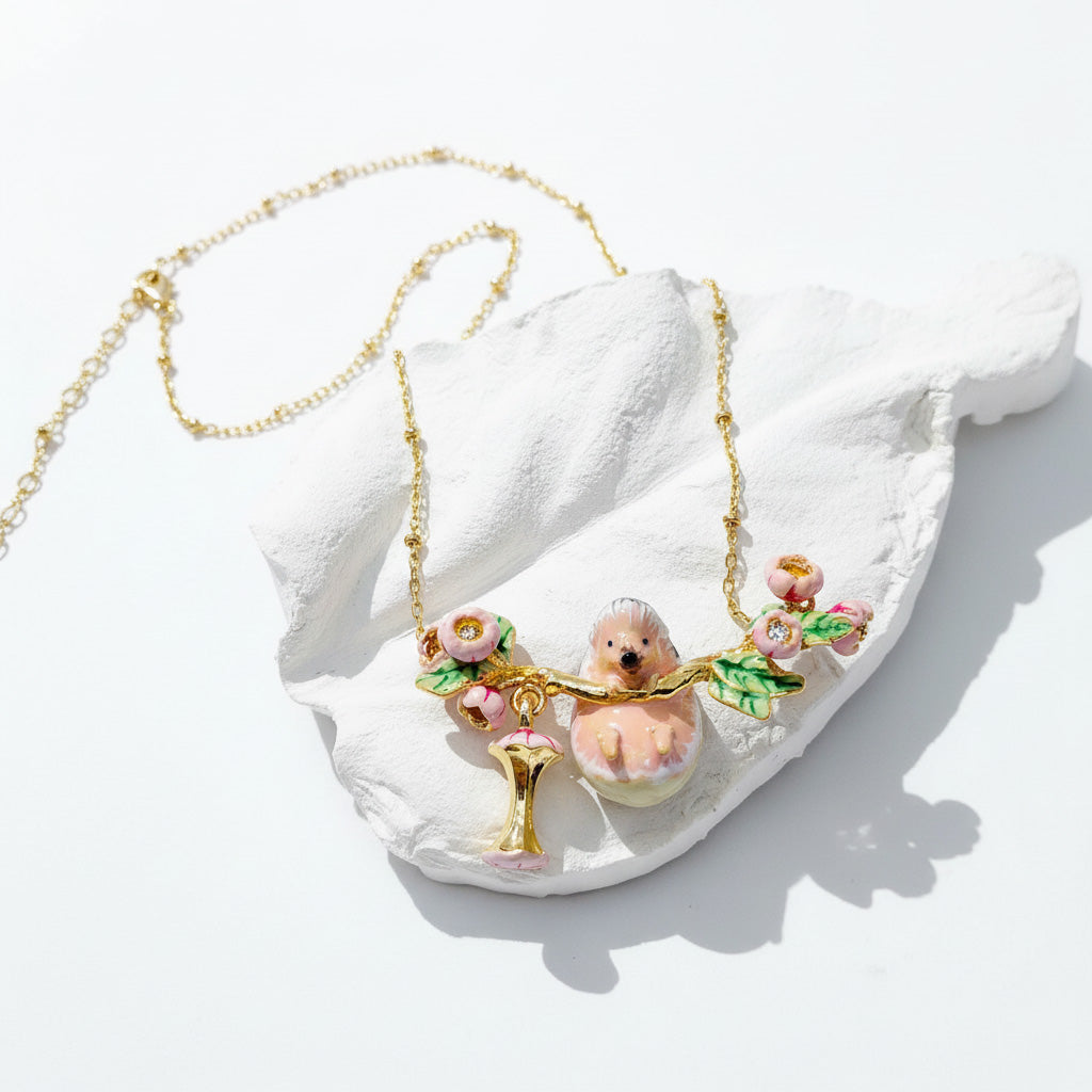 Necklace with a teddy bear and floral pendant on a white shell