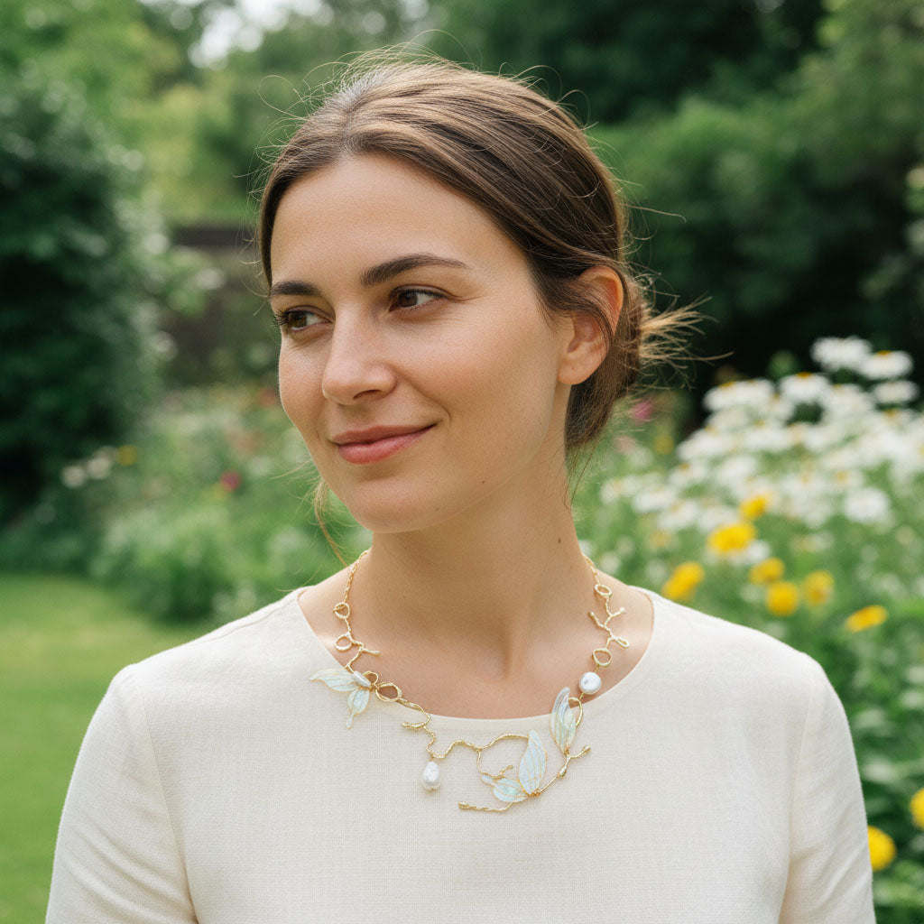 Woman wearing a gold necklace with a floral design outdoors