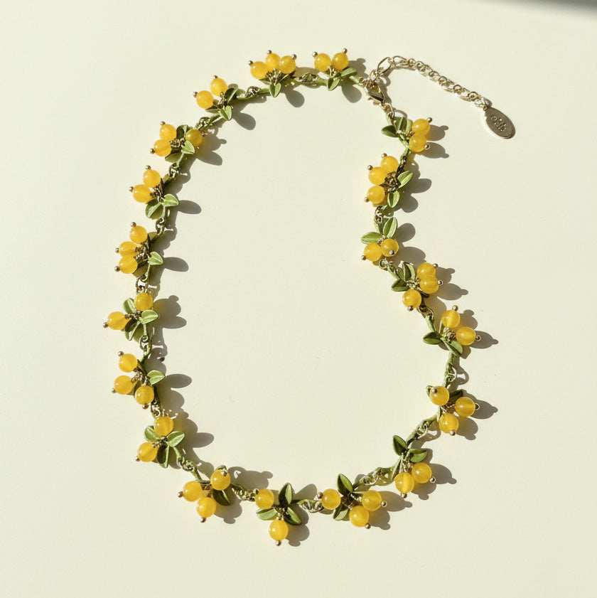 Handcrafted berry garden necklace with yellow semi-precious stone beads and green enamel leaves on gold-plated chain