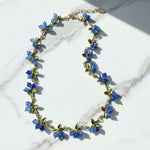 Necklace with blue floral beads on a marble surface
