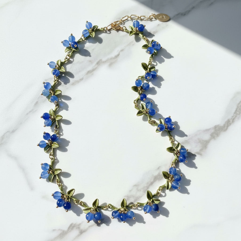 Necklace with blue floral beads on a marble surface