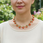 Woman wearing a floral necklace with a blurred green and pink background